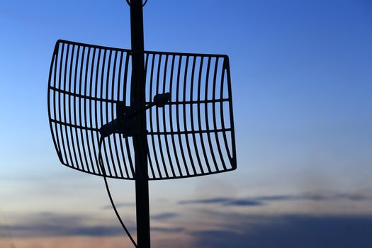 silhouette satellite communication antenna at sunset