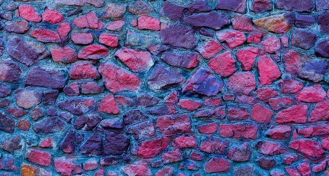 Abstract background of blue and red stones. A wall of blue and red stones.