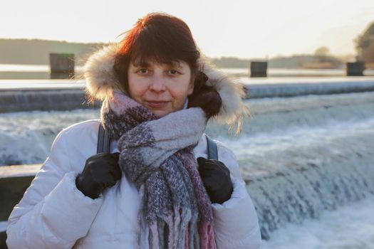 Woman against the background of a water landscape looking at the camera.