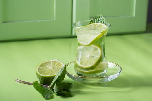 tea with mint and lime, with a calming effect, green still life close-up on a green background, top view. mojito, health drink, alternative medicine.High Quality Photo