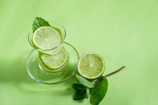 tea with mint and lime, with a calming effect, green still life close-up on a green background, top view. mojito, health drink, alternative medicine.High Quality Photo