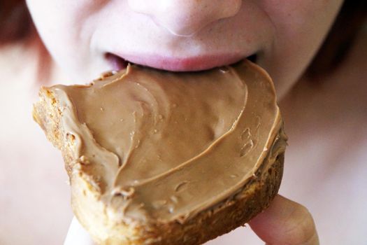 girl biting a peanut butter sandwich close-up