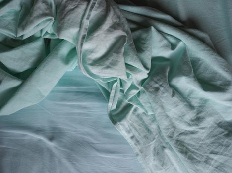 crumpled teal green fabric texture useful as a background