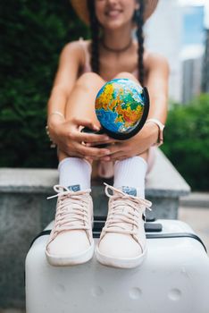 A beautiful young woman holds a small globe in her hands. Lifestyle and travel Concept