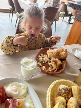 Little girl eats gibanica with a fork. High quality photo