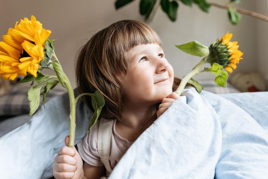 Portrait of a toddler girl holding sunflowers. High quality photo