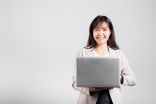 Woman smiling confident smiling holding using laptop computer and typing keyboard for online sending email or chat, Portrait excited happy Asian young female studio shot isolated on white background