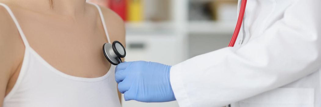 Close-up of female doctor listen to patient chest with stethoscope tool. Concentrated medical worker examine body, diagnostic. Medicine, healthcare concept