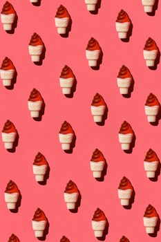 Photo of colorful jelly ice cream cones on light pastel coral background. Top view. Mockup for positive idea. Strict chess order