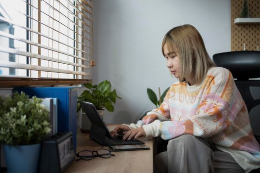 Young female freelancer working with computer table in comfortable home.