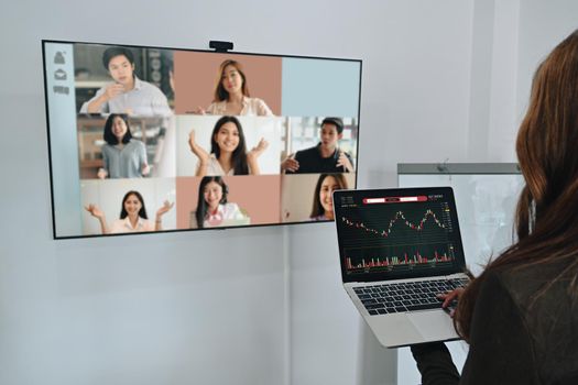 Back view of businesswoman having video conference with diverse colleagues.