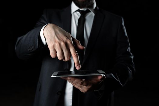 Businessman Holding Tablet And Pointing Important Message With One Finger.