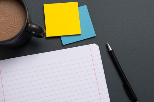 Notebook With Important Message On Desk With Coffee, Pen And Notes.