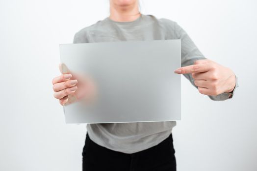 Woman Holding And Pointing At Placard While Promoting The Business.