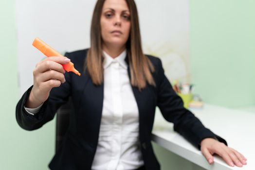 Businesswoman Holding Marker With One Hand And Pointing Important Ideas.