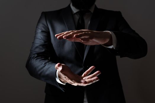 Businessman In Suit Pointing Important Informations Between Hands.