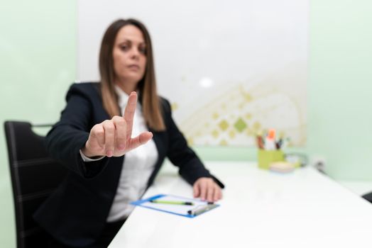 Sitting Businesswoman Pointing Important Infortmations With One Finger.