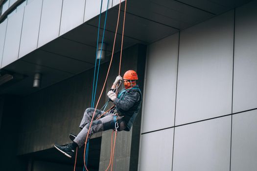 Industrial climber in uniform and helmet rises. Outdoor