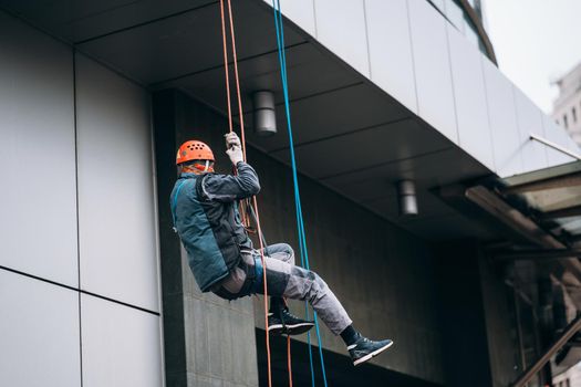 Industrial climber in uniform and helmet rises. Outdoor