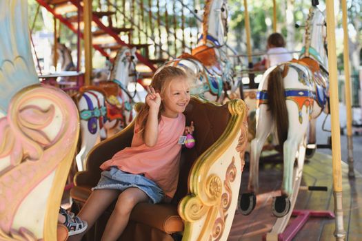 Girl on the carousel.Horses on a carnival Merry Go Round.Carousel