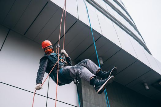 Industrial climber in uniform and helmet rises. Outdoor