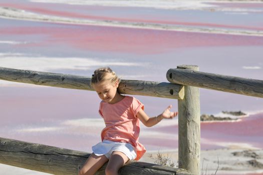 A girl at the Salin-de-Giraud salt farm with pink purple salty water
