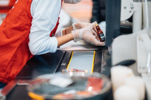 A woman reads the bar code at checkout machine