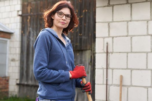 Woman looking at the camera while working in a home vegetable garden