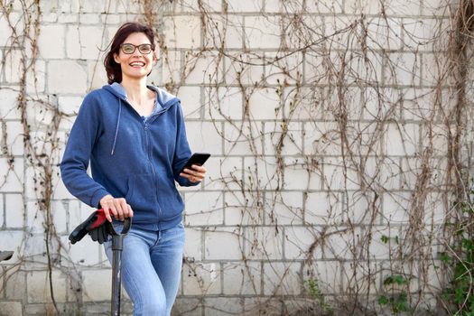 Portrait of a happy woman using a mobile in a vegetable home garden