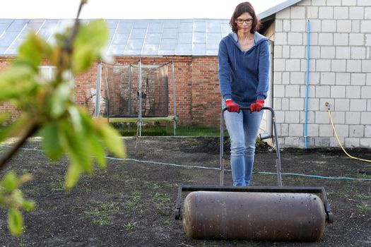 Caucasian woman flattening the land in the traditional way