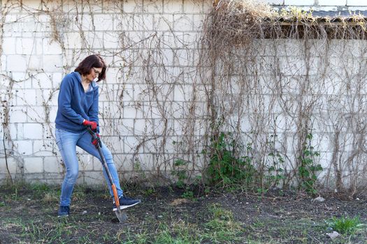 Woman ploughing the land in a home vegetable garden