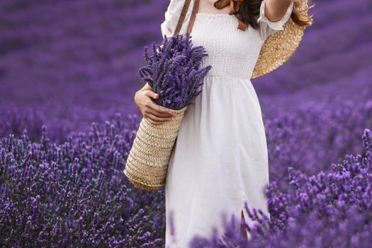 Woman holding wicker basket with a lavender in the field