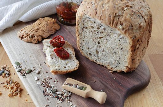 Sliced rye bread on cutting board. Whole grain rye bread with seeds. loaf of homemade whole grain bread and a cut off slice of bread. A mixture of seeds and whole grains. Healthy eating