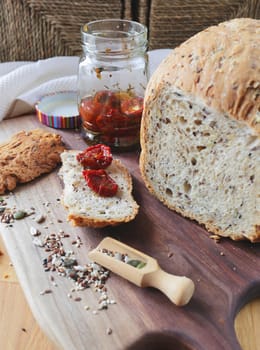 Sliced rye bread on cutting board. Whole grain rye bread with seeds. loaf of homemade whole grain bread and a cut off slice of bread. A mixture of seeds and whole grains. Healthy eating. Vertical image
