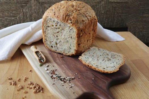 Sliced rye bread on cutting board. Whole grain rye bread with seeds. loaf of homemade whole grain bread and a cut off slice of bread. A mixture of seeds and whole grains. Healthy eating