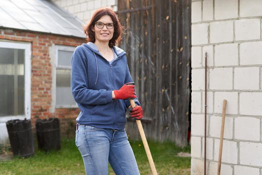 Woman smiling at the camera while working in a home vegetable garden