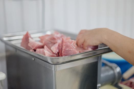 Front view of woman's hands making meat dumpling. The process of making homemade dumplings. Minced meat on dough, the process of cooking italian ravioli. Russian food.