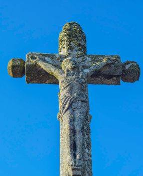 stone cross with a sculpture of the crucified Jesus Christ