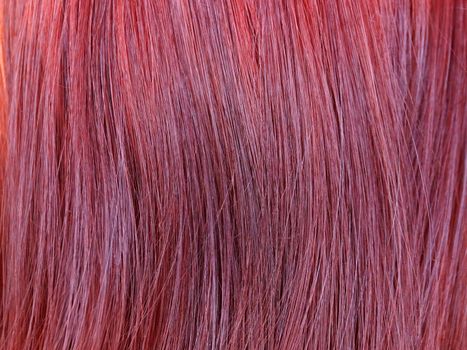 dyed red female hair closeup, texture for background.