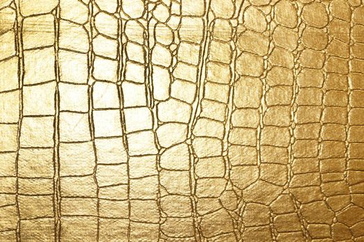 yellow gold crocodile skin texture close up.
