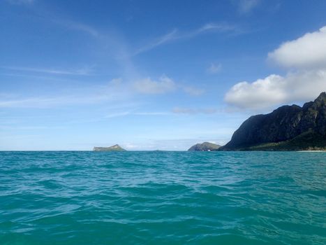 Gentle wave in Waimanalo Bay looking towards Rabbit island and Rock island on nice day Oahu, Hawaii. August 2015..