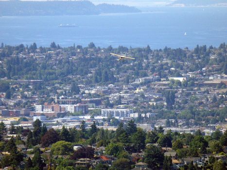 SEATTLE-- JUNE 25:  Aerial view of Small Plane Flies over Seattle with Puget Sound in the distance on June 25, 2016 in Seattle, WA.
