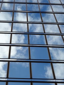 Blue Glass Windows reflect clouds and sky with black lines framing windows.