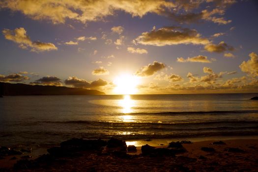 Beautiful Sunset over the ocean with waves moving to rocky shore at Hale'iwa Beach Park on the North Shore of Oahu.    