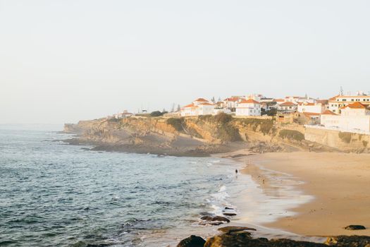 Praia das Macas Apple Beach in Colares, Portugal, on a stormy day before sunset Small city on ocean shore