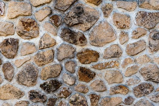 Stone wall composed of irregular blocks of marlstone Texture, background for further work.
