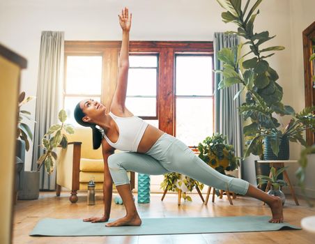 a sporty young woman lunging with her arm extended up at home.