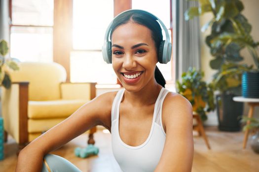 Portrait of a sporty young woman wearing headphones while exercising at home.