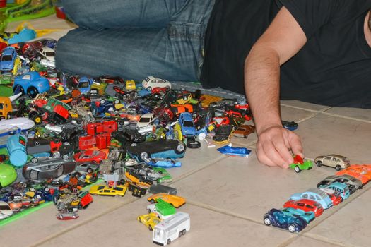 Father plays with son's toy cars