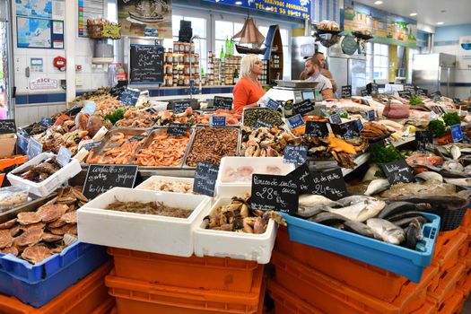 LE TREPORT, FRANCE - OCTOBER 13, 2018: A counter with fresh fish, shrimp, oysters, lobster, snails, scallop,shell at the local famous fish market